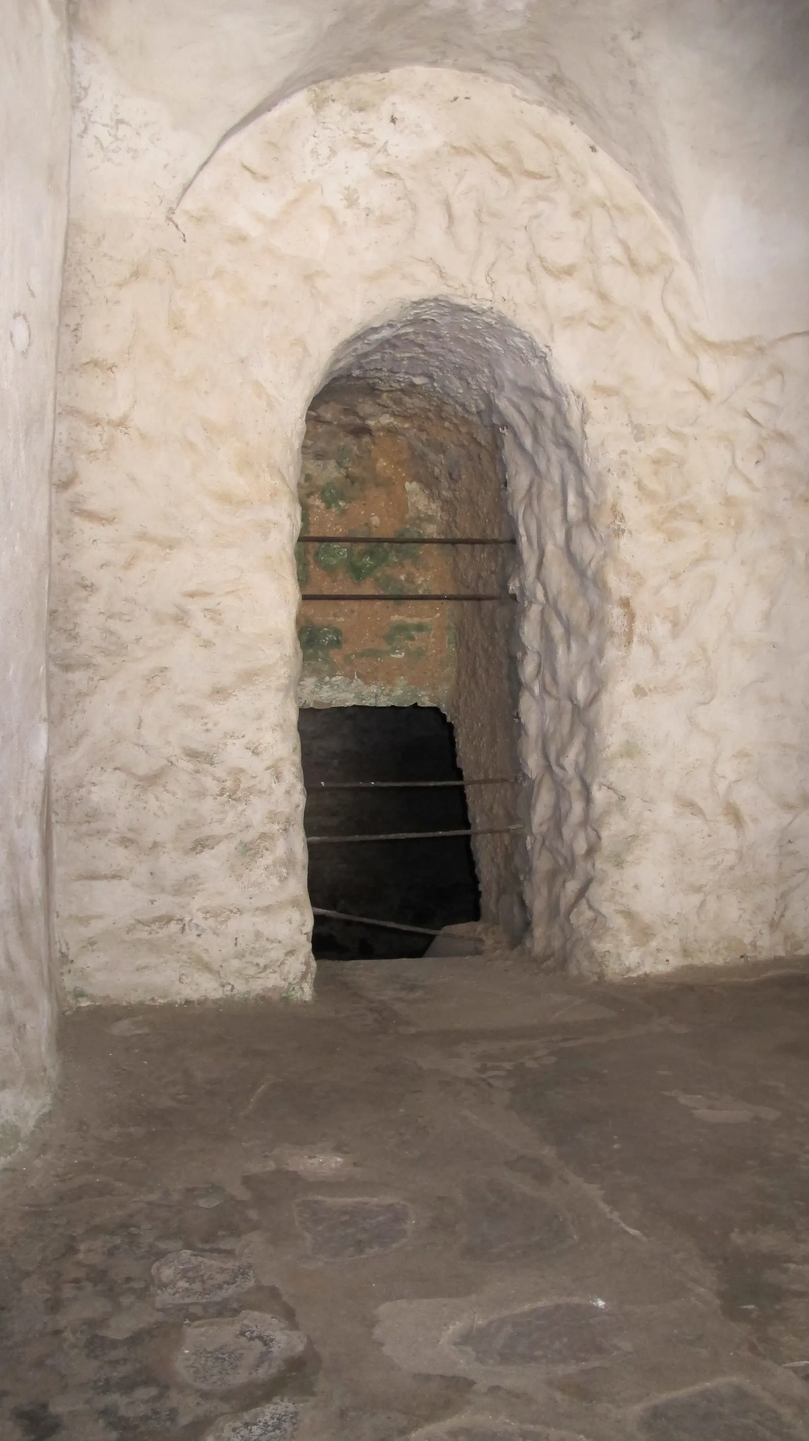 The barred slave export gate at Elmina Castle at the end of a stone passage