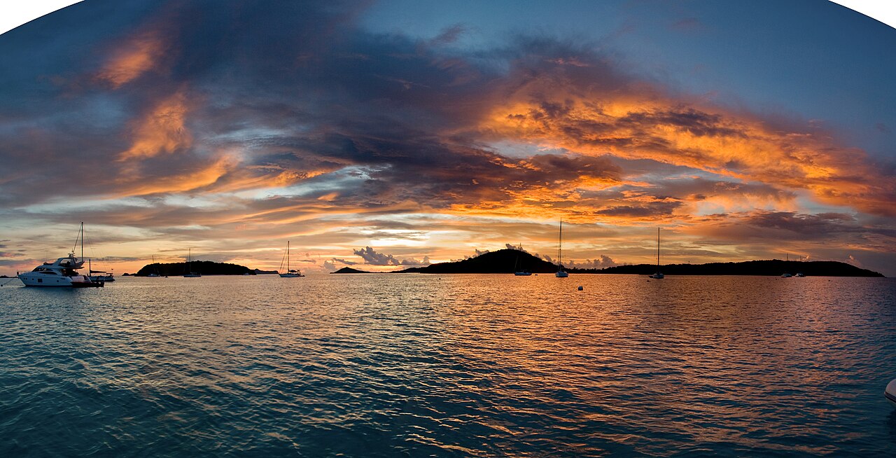 Dramatic sunset over Tobago harbor with silhouetted boats and islands