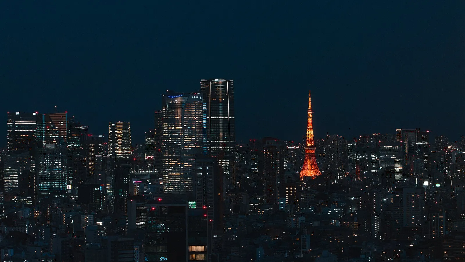 Tokyo skyline at night with illuminated Tokyo Tower glowing orange against city lights