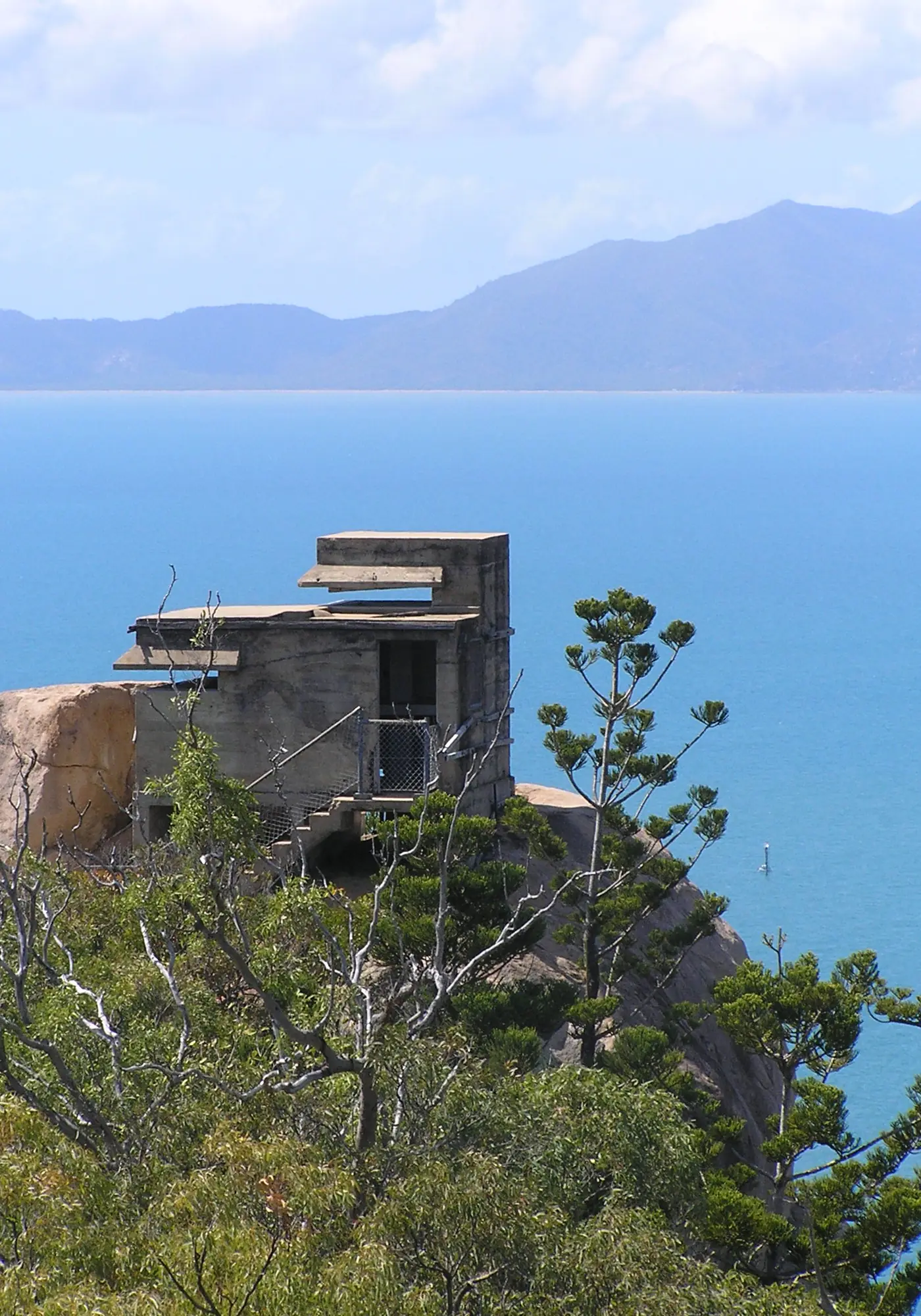 A WWII concrete command and observation post standing on a granite headland on Magnetic Island, with the sea and mainland ranges beyond