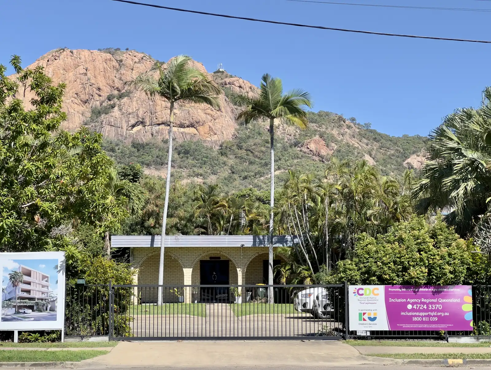 Castle Hill's pink granite face rising behind the rooftops and palms of North Ward, Townsville