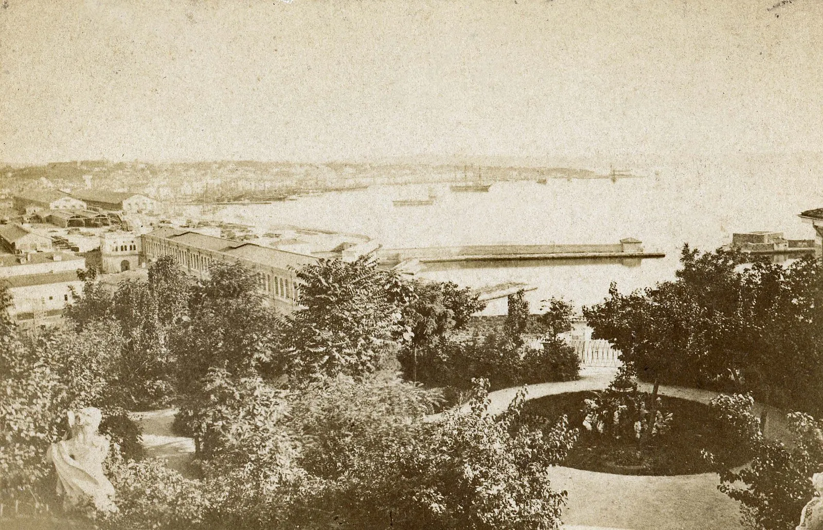 Historical sepia photograph of Trieste harbor from elevated garden showing port and breakwater
