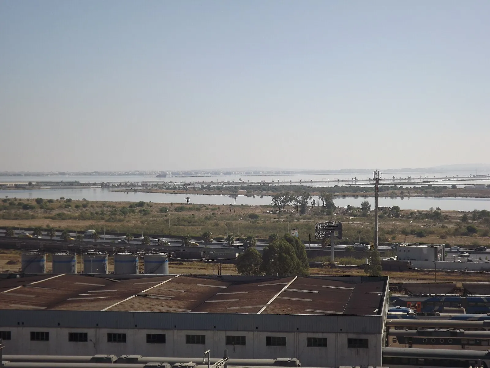 Tunis port industrial area with Lake of Tunis, warehouses, storage tanks, and rail yards