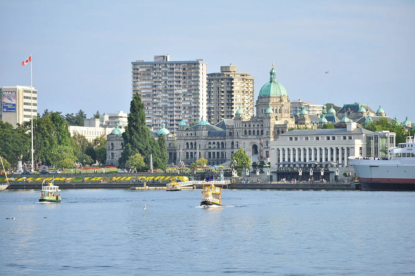 Victoria Inner Harbour showing Parliament buildings, water taxis, and Welcome to Victoria flower banner
