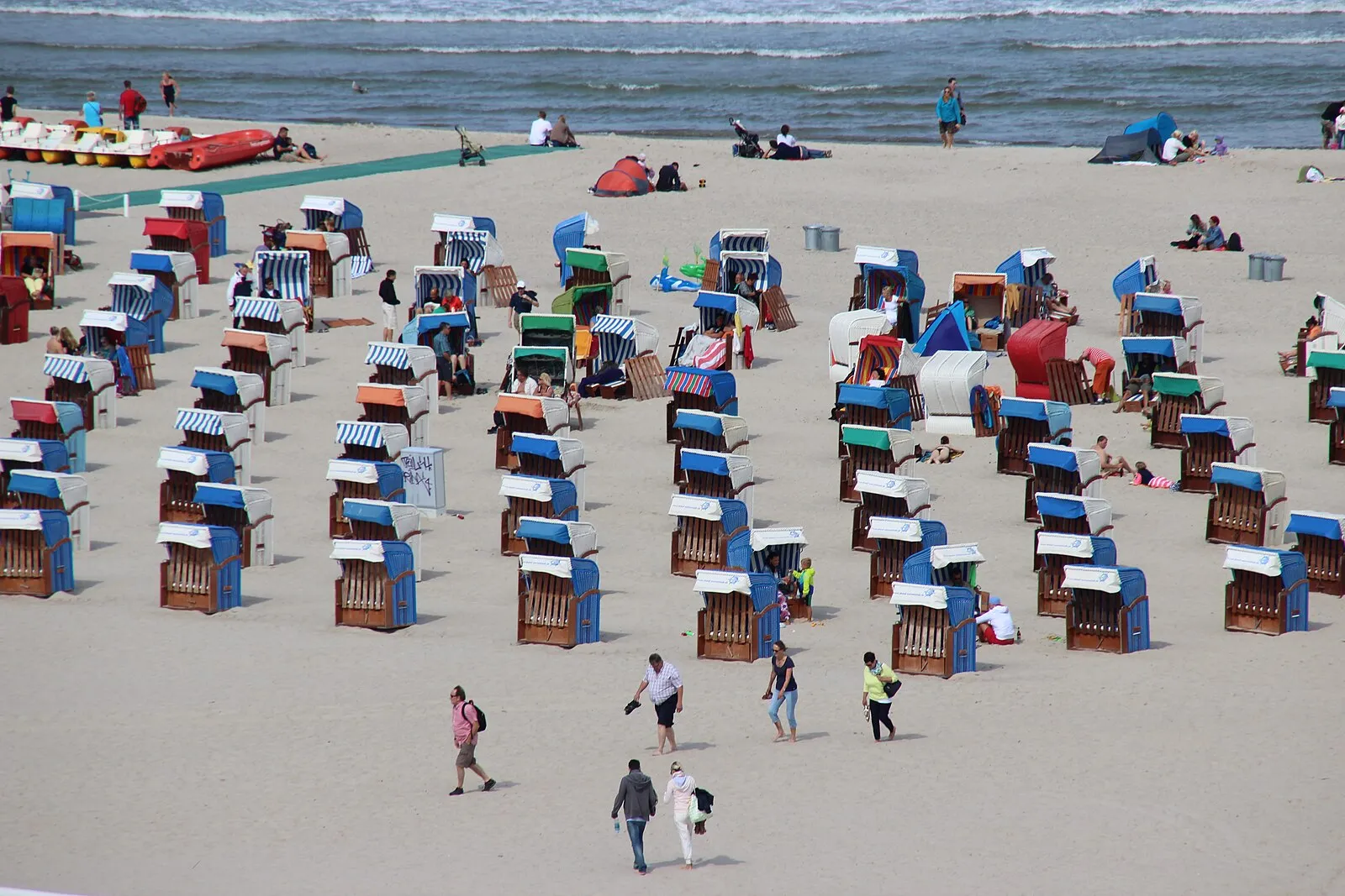 Colorful Strandkörbe hooded beach chairs from above on Warnemünde sand beach with Baltic Sea