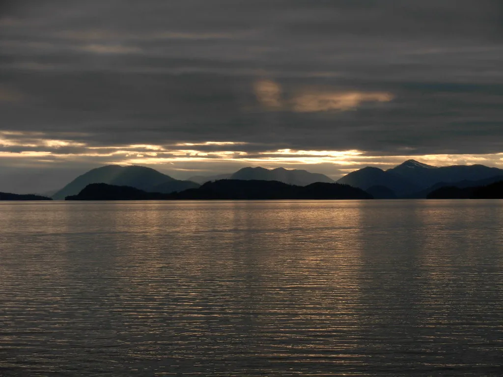 Sunset over the water near Wrangell with silhouetted mountains and dramatic clouds