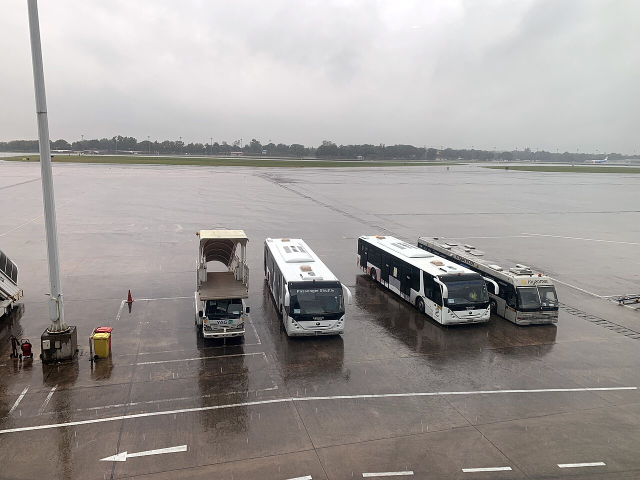 Yangon River waterfront with traditional ferries and cargo vessels near Botataung Jetty and the city skyline beyond